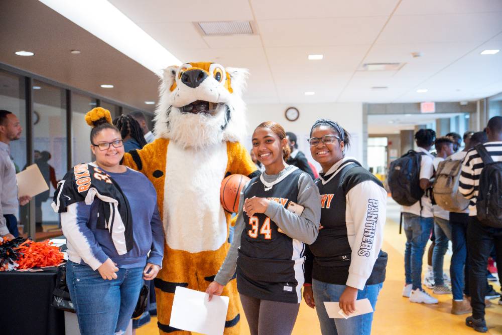 students posing with mascot